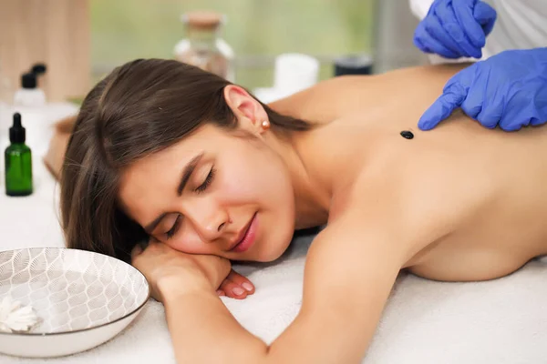 Jonge vrouw genieten van massage in spa salon — Stockfoto