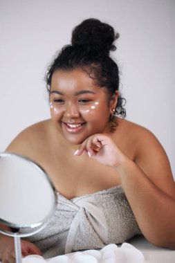 Yüz kremi. Beyaz havluyla güzel bir kadın.,