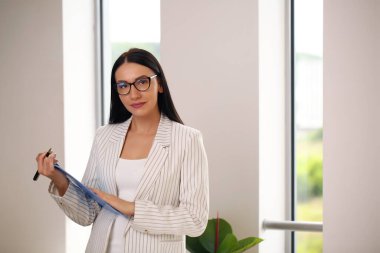 Dosyası olan genç bir iş kadını, takım elbiseli bir esmer..