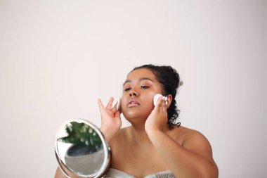 Afro kadın evde cildiyle ilgileniyor..