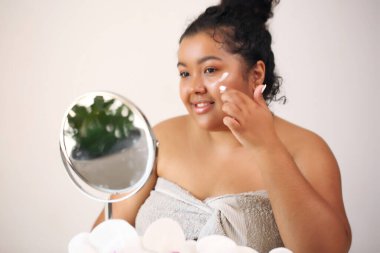 Afro kadın evde cildiyle ilgileniyor..