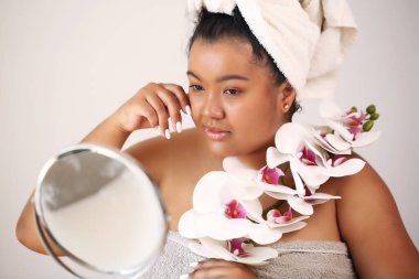 Kişisel gelişim. Bornozlu güzel Afrikalı Amerikalı kadın makyaj yapmaya hazır.