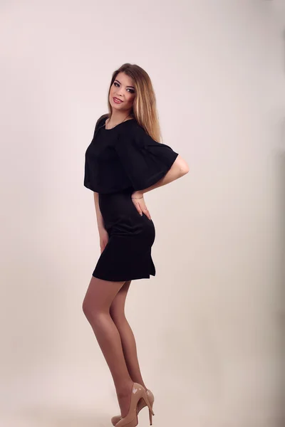Beautiful sexy woman in black dress posing in studio — Stock Photo, Image