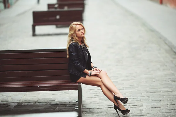 Atractiva joven adulta sonriente sentada en un banco en Lviv —  Fotos de Stock
