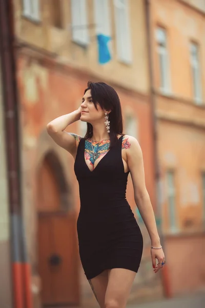 Hermosa chica en vestido negro caminando en la ciudad — Foto de Stock