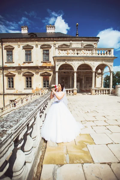 Gorgeous young brunette bride against to castle in west Ukraine — Stock Photo, Image