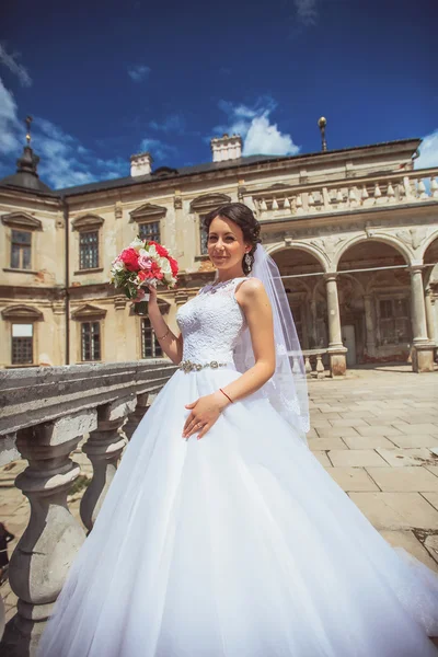 Beautiful bride runs between the columns — Stock Photo, Image