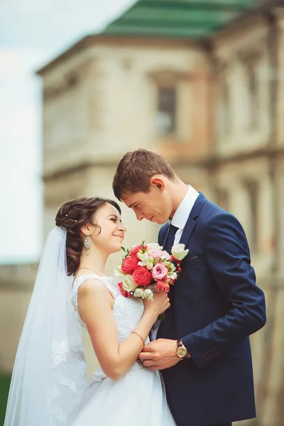 Красивая пара в свадебном платье на открытом воздухе возле замка — стоковое фото