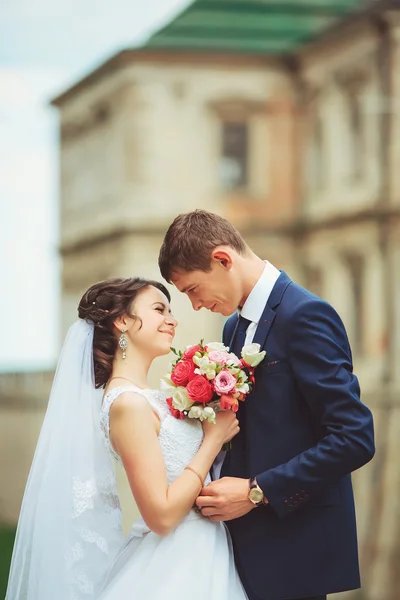 Beautiful couple in wedding dress outdoors near the castle — Stock Photo, Image