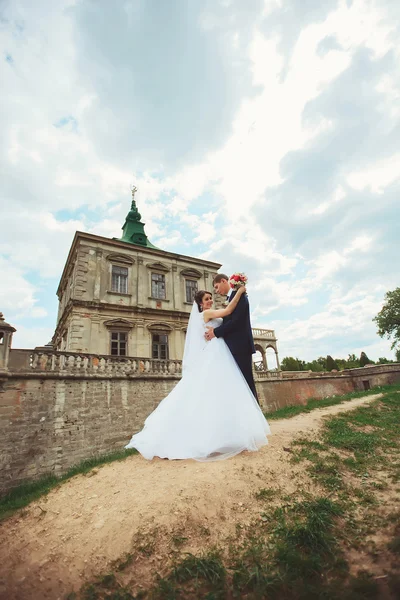 Schöne glückliche Braut und Bräutigam posiert in einem Hof von mittelalterlichen cas — Stockfoto