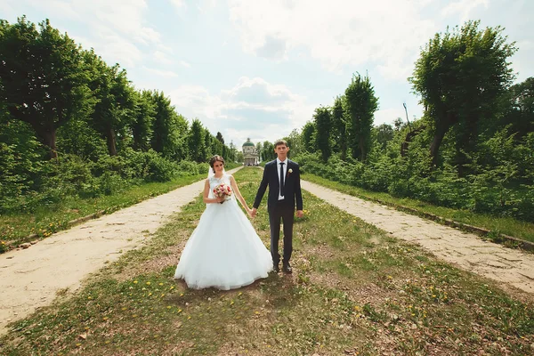 Braut und Bräutigam am Hochzeitstag beim Spaziergang in der Natur des Frühlings — Stockfoto