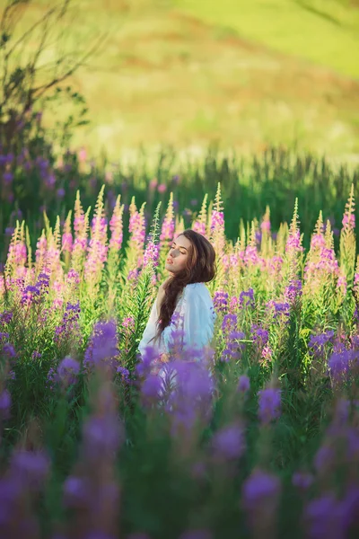 Vacker flicka i en blommig trädgård — Stockfoto