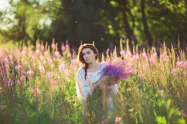 Vacker ung flicka, hålla lavendel i ett fält på sunset. Wal — Stockfoto