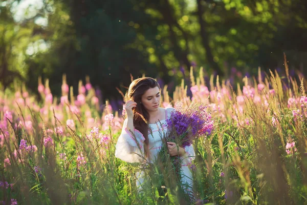 Hermosa joven, sosteniendo lavanda en un campo al atardecer. WAL — Foto de Stock