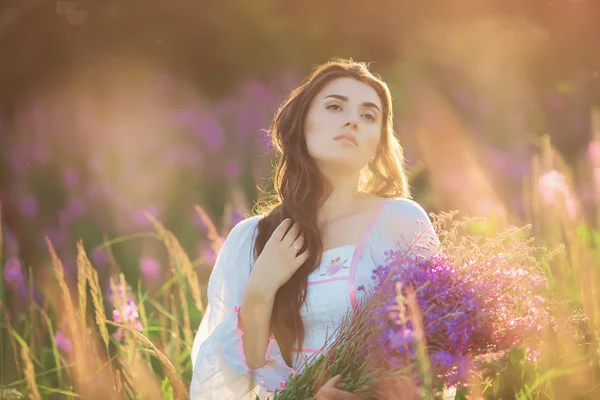 Krásná mladá dívka, šťastný, drží levandule v poli slunce — Stock fotografie