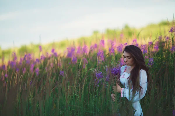 Tjej söker charmiga utseende, långa glänsande hår i lavendel fält — Stockfoto