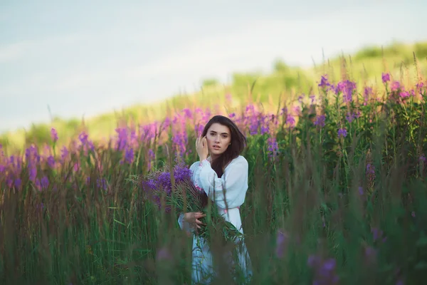 Девушка выглядит очаровательно, длинные блестящие волосы в лавандовом поле — стоковое фото