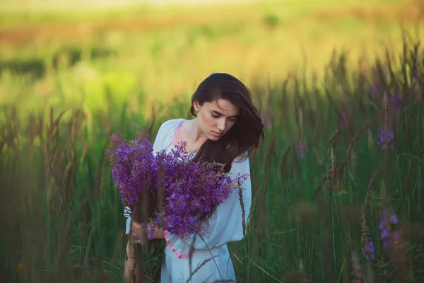 Flicka i en lång vit klänning, står i ett fält av lavendel, lav — Stockfoto