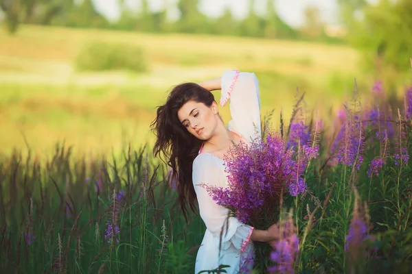 Девушка в поле, красивое белое длинное платье — стоковое фото