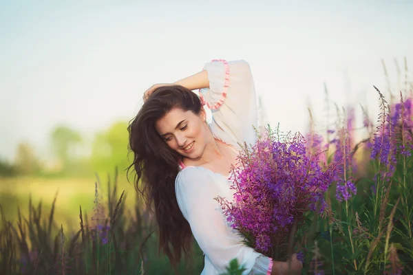 Happy girl smiling, looking at the ground in a field — Stock Photo, Image