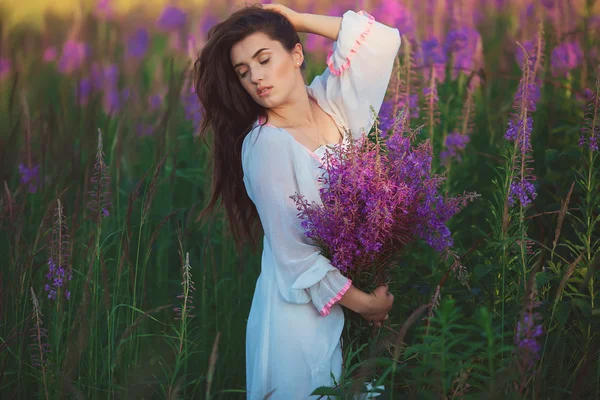 Una donna con gli occhi chiusi, in posa in un campo di lavanda, alcool — Foto Stock