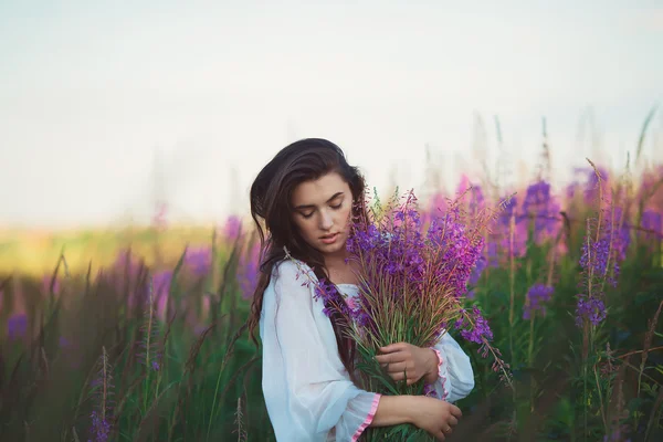 Una donna con gli occhi chiusi, in posa in un campo di lavanda, alcool — Foto Stock