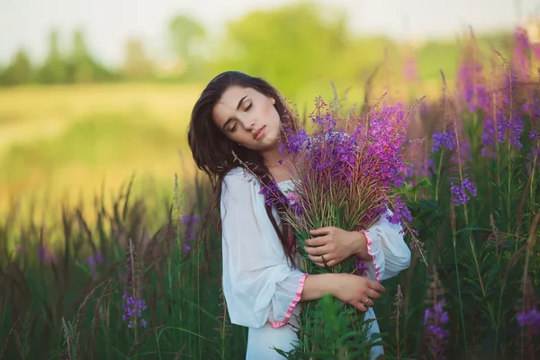 Una donna con gli occhi chiusi, in posa in un campo di lavanda, alcool — Foto Stock