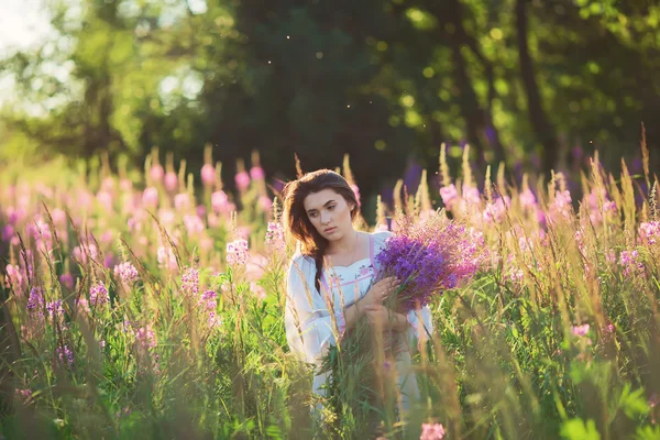 Bella giovane donna, che tiene la lavanda in un campo al tramonto. Quindi... — Foto Stock