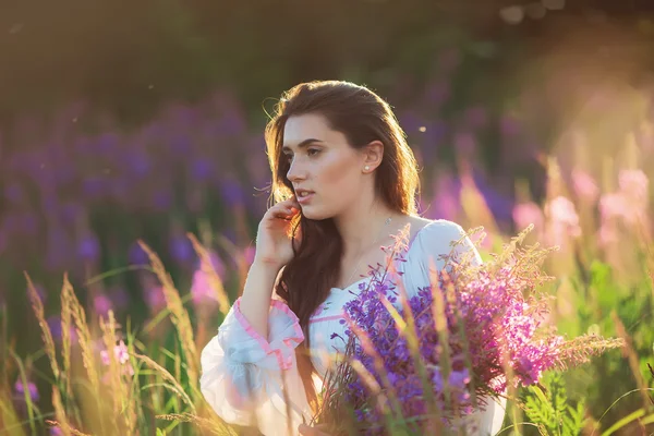Beautiful young girl, holding lavender in a field on sunset. wal — Stock Photo, Image
