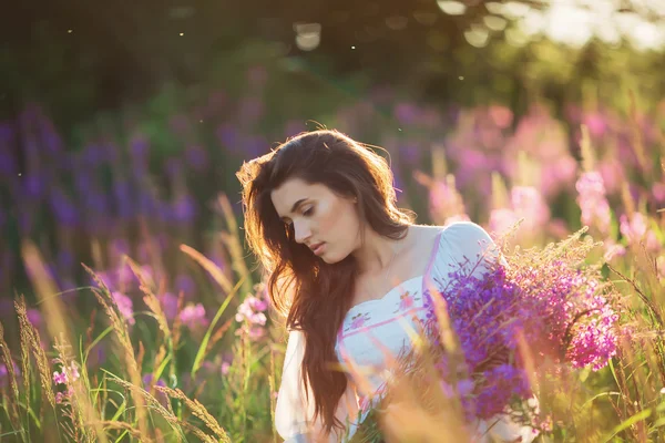 Hermosa joven, sosteniendo lavanda en un campo al atardecer. WAL — Foto de Stock