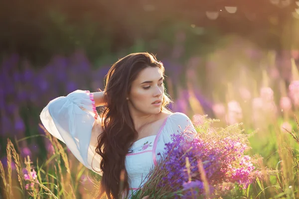 Schönes junges Mädchen, Lavendel in einem Feld bei Sonnenuntergang haltend. wal — Stockfoto