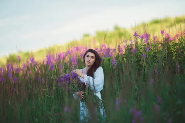 Tjej söker charmiga utseende, långa glänsande hår i lavendel fält — Stockfoto