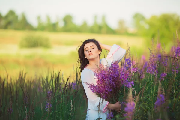 Fille aux yeux fermés, debout dans un champ pose — Photo