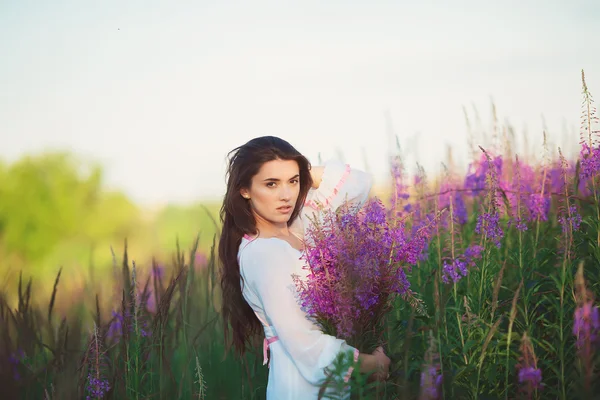 Menina de beleza fica no campo, posando — Fotografia de Stock