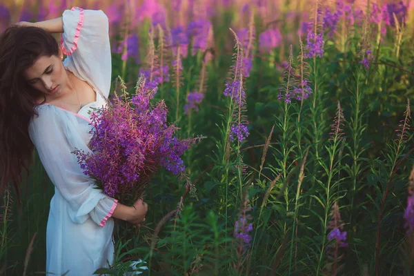 Una donna con gli occhi chiusi, in posa in un campo di lavanda, alcool — Foto Stock