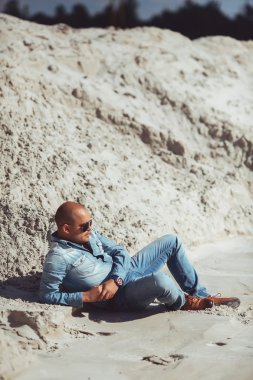 Portekiz'de kum yatan kot pantolon giysili genç adam