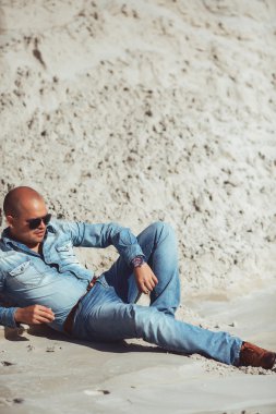 Maldivler kuma yatan kot pantolon giysili genç adam