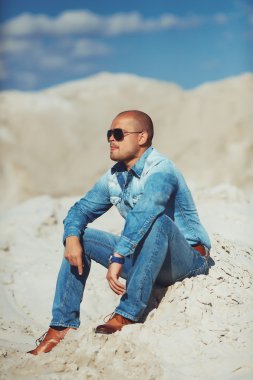 Kum bir arka plan üzerinde mutlu bir adam portresi tam uzunlukta