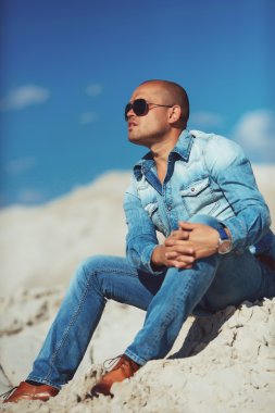 Yakışıklı genç adam dışarıda gülümsüyor.