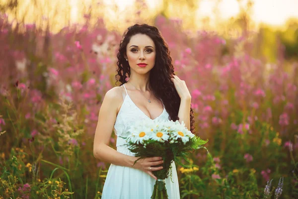 Bella giovane ragazza in piedi con un bouquet nelle mani holdin — Foto Stock