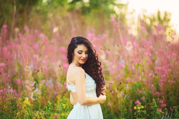 Vrouw met schoonheid lang bruin haar staande in veld — Stockfoto