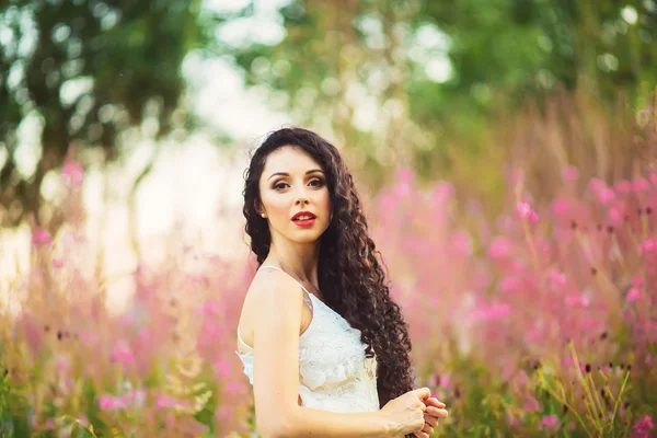 Mulher bonita em flores roxas ao ar livre — Fotografia de Stock