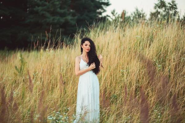 Beautiful young woman in purple flowers outdoors — Stock Photo, Image