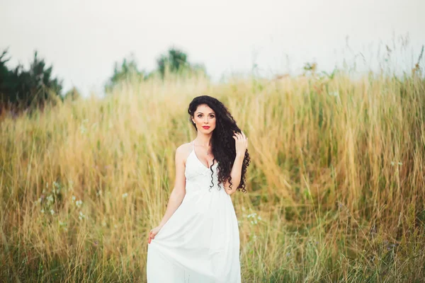 Bella ragazza in un campo in abito bianco ha bello lon — Foto Stock