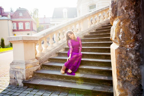 Menina sorrindo no fundo do edifício velho senta-se no s — Fotografia de Stock