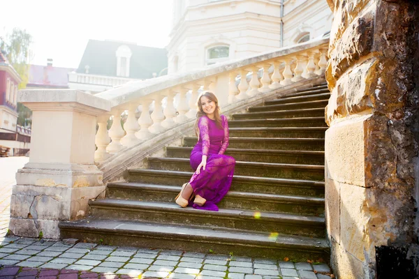 Chica sonriendo en el fondo del viejo edificio se sienta en el s — Foto de Stock