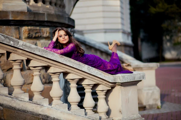 Junge Frau auf dem Geländer in der Nähe einer antiken Burg liegend. — Stockfoto