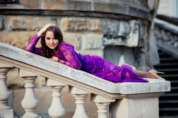 Young woman lying on the railing near of an ancient castle.Beaut — Stock Photo, Image