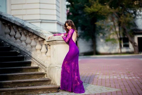 Young woman standing near the walls of an ancient castle blue vi — Stock Photo, Image