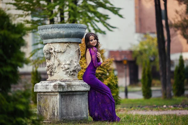 Belle fille dans une robe de luxe promenades dans le parc d'automne près de th — Photo